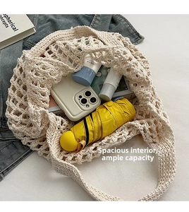 Close-up of beige crochet tote bag showing spacious interior with umbrella and phone