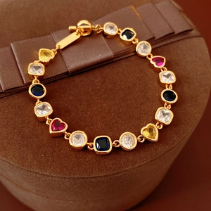 Gros plan d'un bracelet vintage doré orné de zircons multicolores en forme de cœur et rond