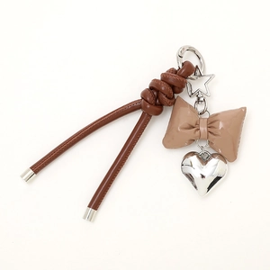 Brown braided leather keychain with bow pendant and heart charm on star ring