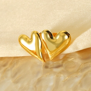 Polished 18K gold-plated heart stud earrings on elegant silk and water texture background