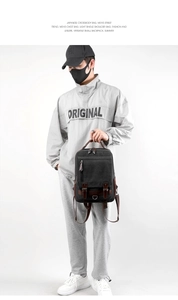 Men's retro black canvas backpack with leather straps shown in a lifestyle model shot
