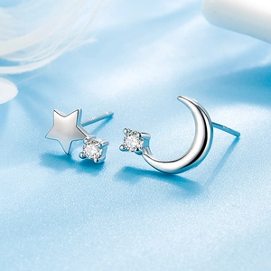 Sparkling S925 silver star and moon stud earrings with zircons on blue silk background