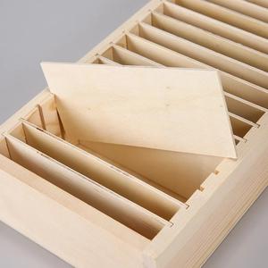 Close-up of wooden storage box slots showing natural grain and removable dividers