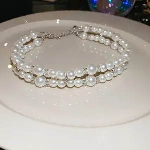 Double-layered pearl necklace with crystal beads and elegant silver cross pendant