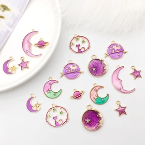 Dettaglio di ciondoli smaltati colorati con design a stelle, lune e pianeti per DIY