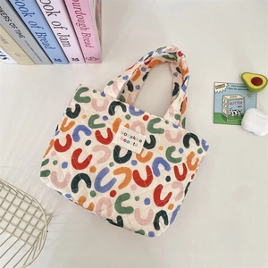 Vue de dessus d'un sac cabas matelassé aux motifs en U colorés et aux poignées souples