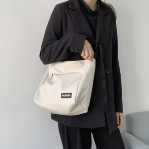 White canvas messenger bag shown cross-body on a model for a stylish streetwear look