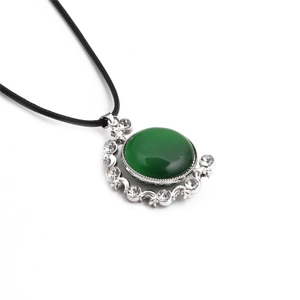Detail of green oval crystal stone pendant with rhinestone border on black cord