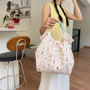 Cute seersucker tote bag with bear pattern and blue braided handles shown in a cafe setting
