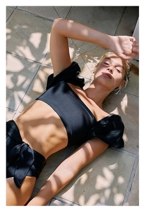 Detail von schwarzem Bikini-Top mit Puffärmeln und High-Waist-Hose mit Seitenschleife
