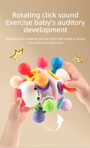 Detail of hands rotating the colorful sensory rattle toy for baby auditory development