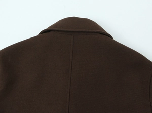 Detail of dark brown wool coat showing lapel stitching and thick knit texture