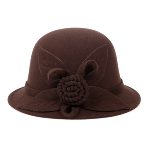 Detail of elegant handmade wool floral decoration on a brown wool felt cloche hat