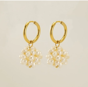 Détail de créoles plaquées or 18k avec pendentifs de grappes de perles blanches