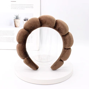 Detail of a brown padded corduroy headband with a thick cloud-like segment design