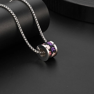 Close-up of cylinder pendant with colorful glass beads on a steel box chain