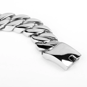 Macro detail of high-polish silver cuban link chain with box clasp closure on white background