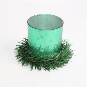 Christmas pine needle candle ring with a textured green glass holder on white background