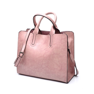 Detail of pink faux leather handbag with detachable shoulder strap and black oil edges