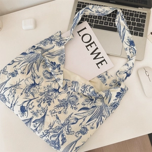 Canvas tote bag with blue floral print shown with laptop and tech accessories on desk