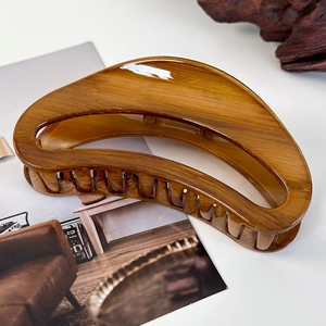 Close-up of a large tortoiseshell claw clip with smooth crescent cutout on a magazine