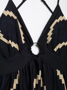 Détail du décolleté en V avec anneau argenté et motif zigzag beige sur tissu noir