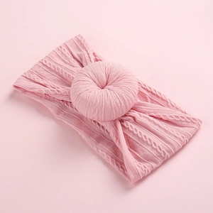 Close-up of pink jacquard knit nylon baby headband with a soft donut knot texture
