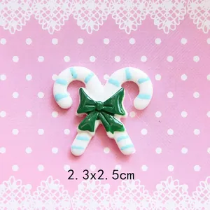Detail of Christmas candy cane resin charms with green bow for DIY craft projects