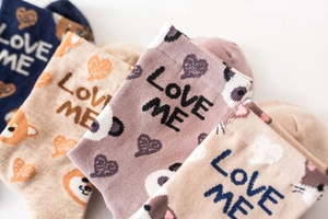 Detail of cotton crew socks featuring cute animal patterns and LOVE ME knit lettering