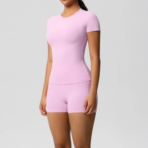 Detailed close-up of pink brushed nylon yoga set featuring high-waist shorts and short sleeves