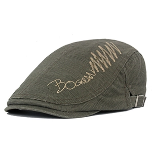 Detail of dark green cotton newsboy cap featuring side embroidery and adjustable metal buckle