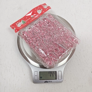 Pink acrylic spiral icicle ornaments shown on a digital scale for weight measurement