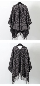 Detail of grey leopard print knitted poncho featuring stylish black fringe tassels