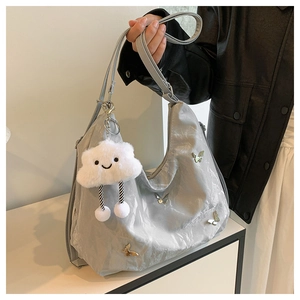 Close-up of silver-grey butterfly shoulder bag with a white fluffy cloud pendant