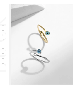 Detail of adjustable gold and silver rings with turquoise evil eye motifs in ins style
