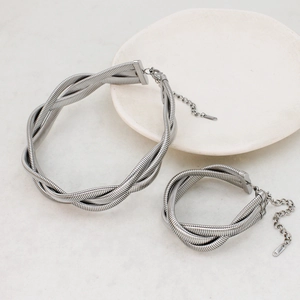 Detailed close-up of silver triple-strand braided necklace and bracelet set with lobster clasp