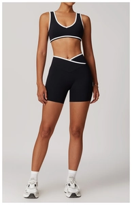 Detail of cross-waist gym shorts and racerback sports bra with contrast piping