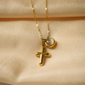 Golden cross and moonstone double pendant necklace on elegant champagne silk background