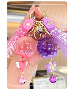 Close-up of cute liquid oil wind chime keychains in pink and purple held by hand