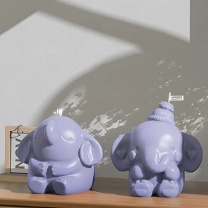 Cute purple elephant scented candles in two poses on a rustic wooden surface