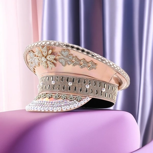 Macro shot of rose gold leather captain hat featuring sparkling rhinestones and pearls