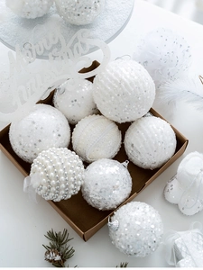 Macro view of white Christmas tree ornaments with sequins and pearls in a gift box