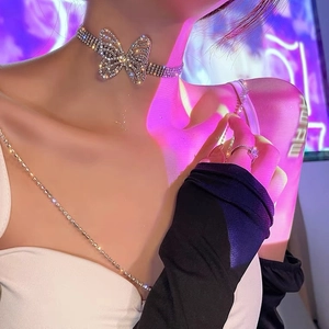 Close-up of sparkling rhinestone butterfly choker and matching ring on model neck