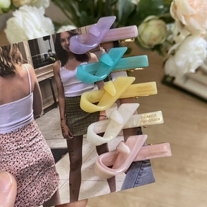 Five colorful acetate knotted hair clips in purple, blue, yellow, white, and pink sets