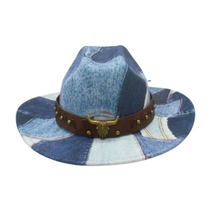 Detail of denim patchwork cowboy hat with brown leather strap and golden bull head