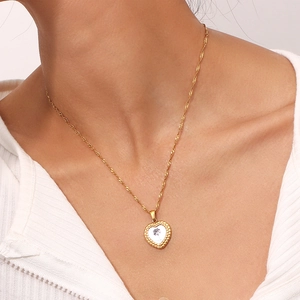 Détail du collier cœur plaqué or 18K avec incrustation de nacre et motif floral noir