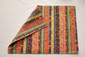Detail of French cotton linen napkin with ethnic colorful stripes and edge stitching