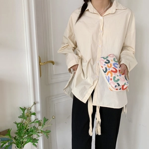 Dettaglio di una trousse trapuntata a fiori con motivi colorati e zip di chiusura