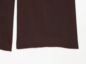 Gros plan sur la texture à fines rayures brunes et les coutures du bas du pantalon