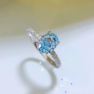 Macro shot of oval blue gemstone ring with pave diamonds on a silver band